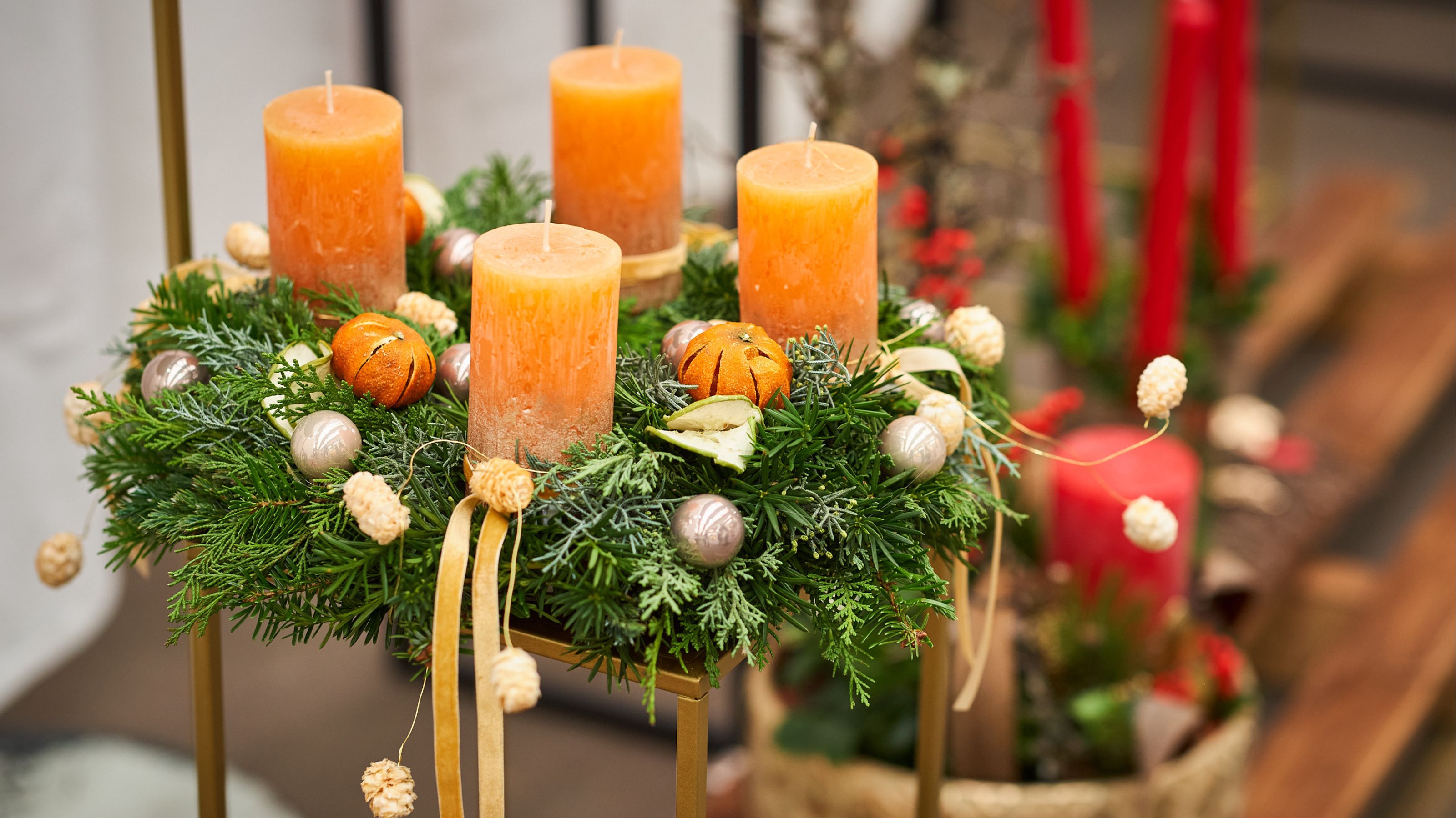 Ein Adventkranz mit orangen Kerzen