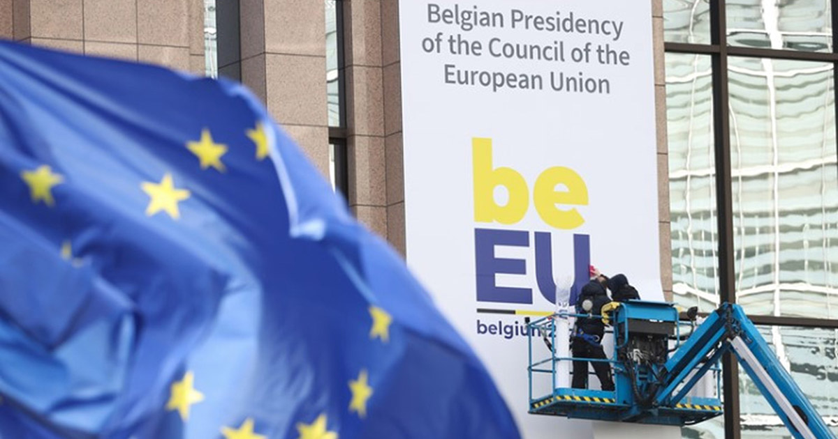 die Europäische Flagge - im Hintergrund wird ein Banner zur belgischen Ratspräsidentschaft angebracht