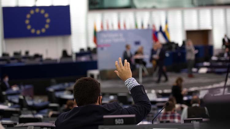 Ein Mann hebt die Hand im Europäischen Parlament