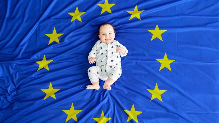 Ein Baby liegt auf der Europäischen Flagge
