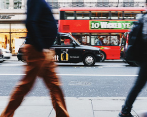 bewegungsunscharfe Silhouetten von Spaziergängern vor Auto und Bus in London