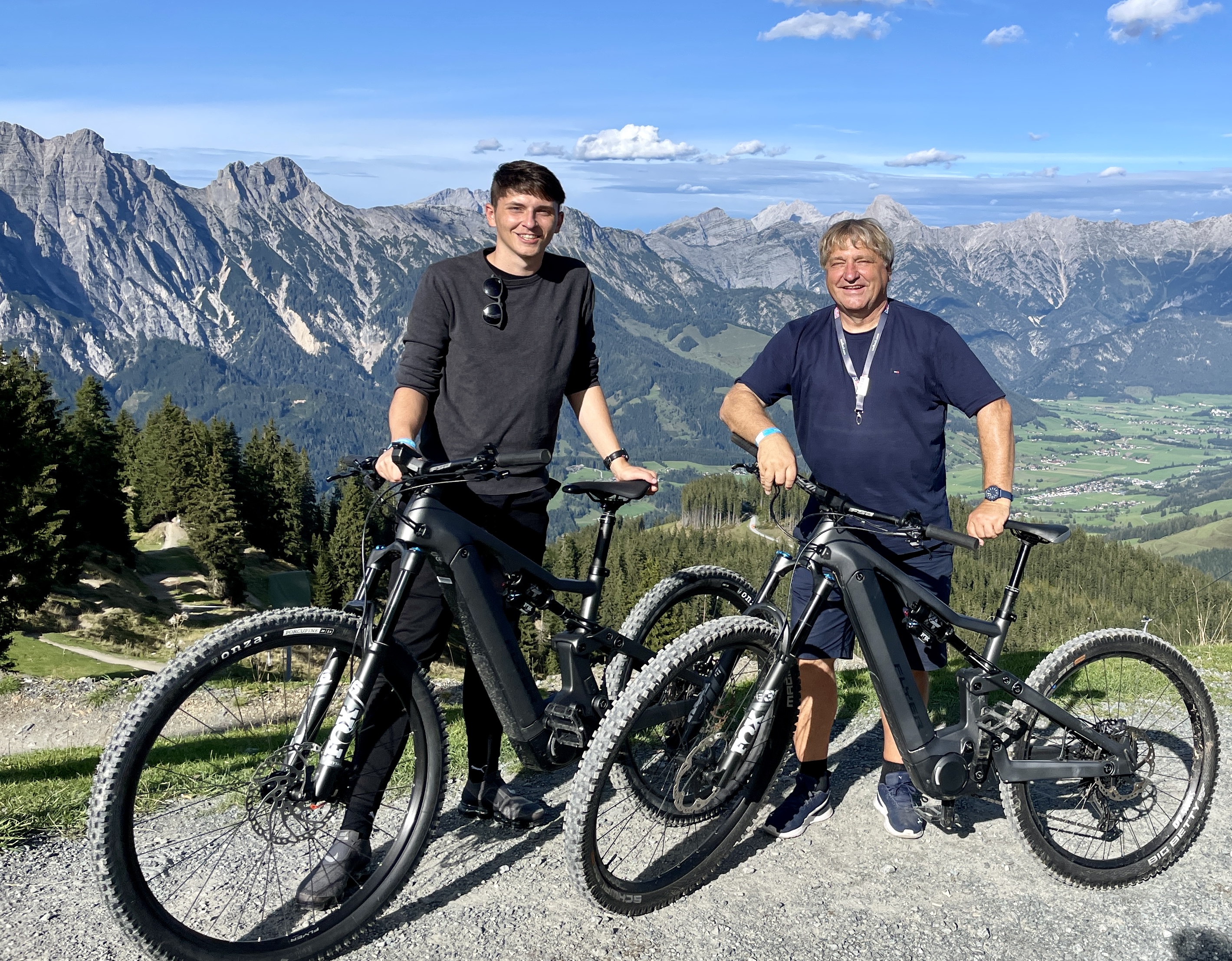 Nico und Gerhard Bauer mit E-Bikes vor schöner Gebirgslandschaft