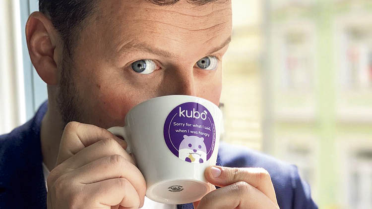 Kubo-Gründer Dominik Hütter mit einem Häferl mit Kubo-Sticker. 